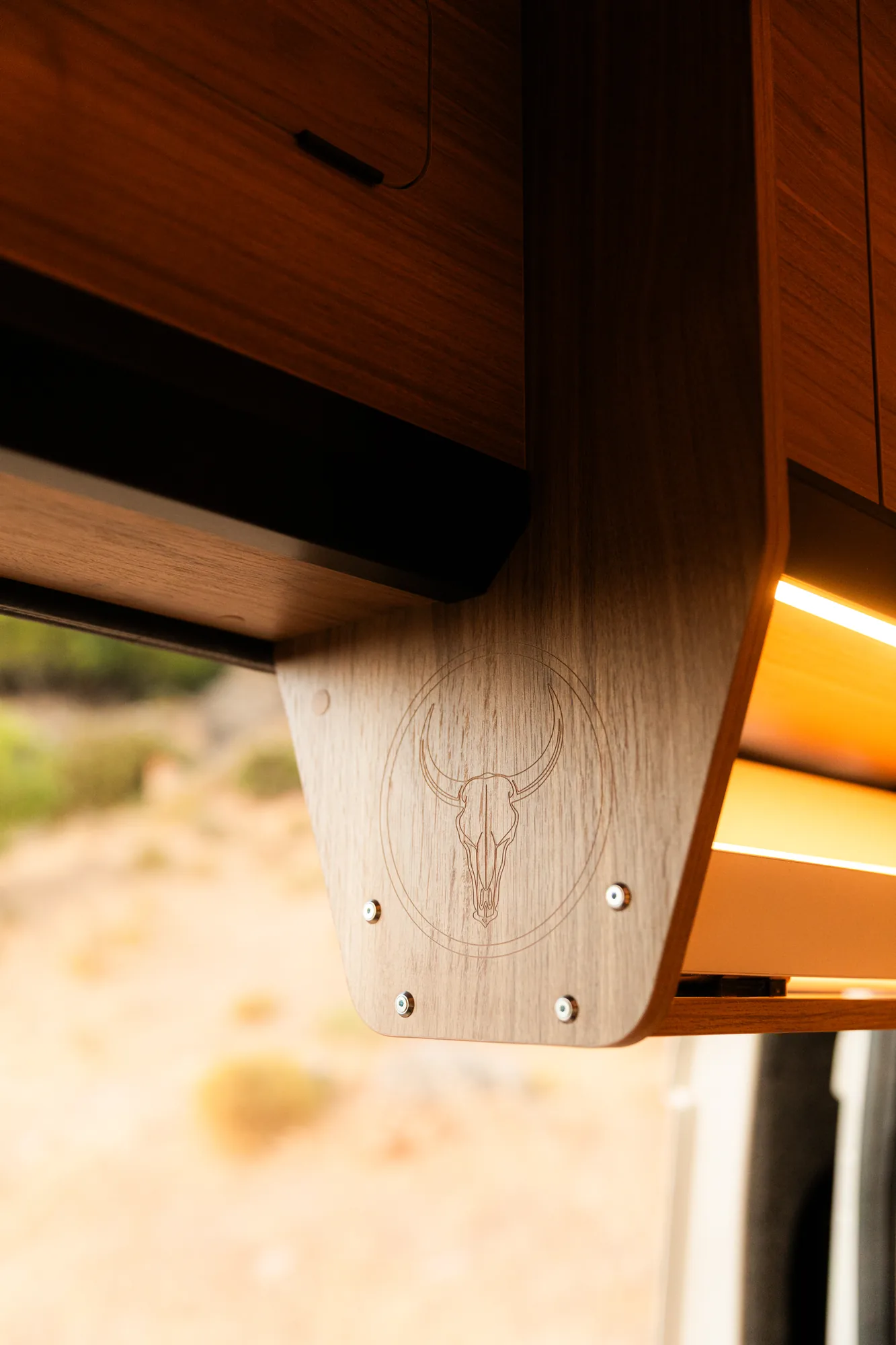 Mueble alto de madera con el logo Bullcamper grabado e iluminación LED