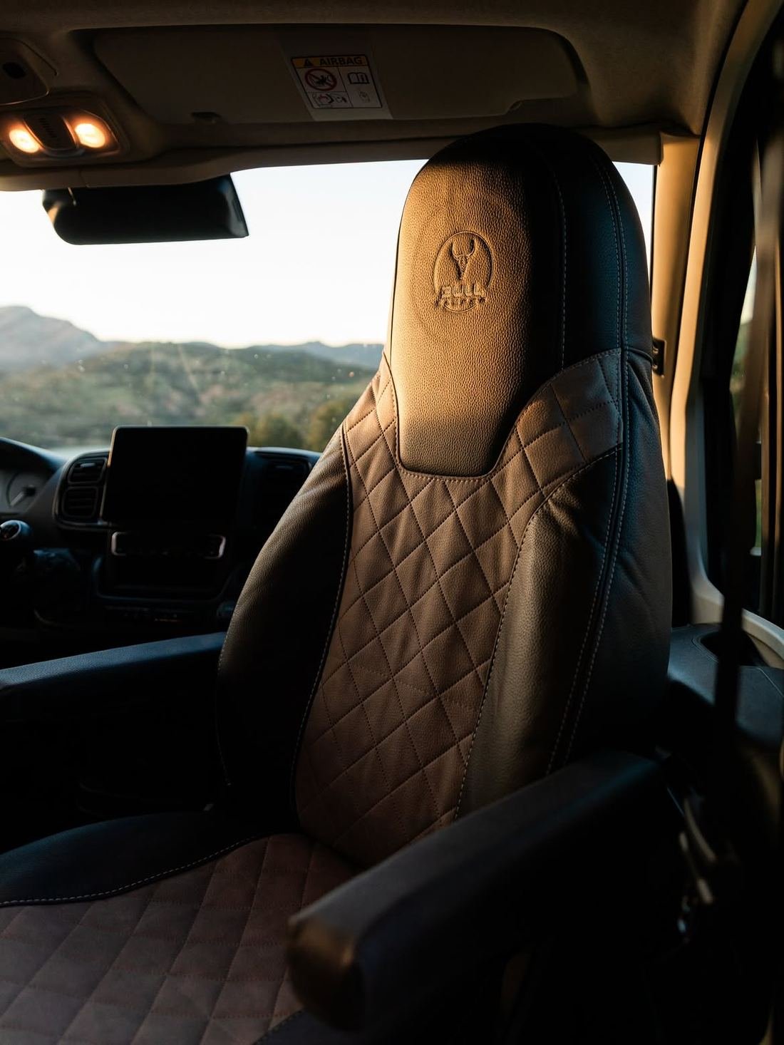 Asiento de cuero acolchado con el logo de Bullcamper grabado en el reposacabezas